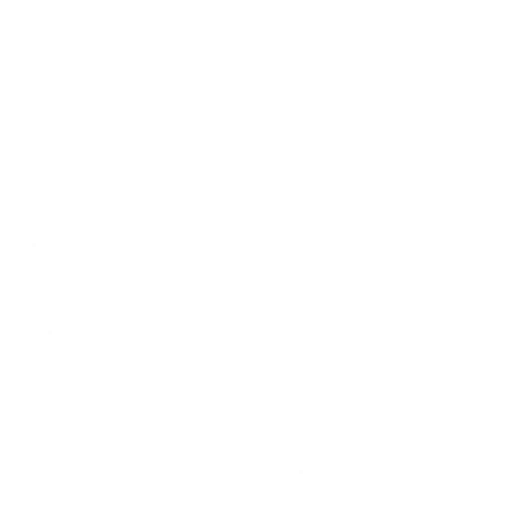 Ein kreisförmiges Logo, das Berggipfel über einem Globus zeigt und von den Schriftzügen „IVBV“, „IFMGA“, „UIAGM“ sowie Übersetzungen des Begriffs „Bergführer“ in verschiedenen Sprachen umgeben ist, steht für Spitzenqualität bei geführten Bergtouren.